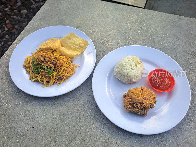 炒面和炸鸡饭放在盘子里。Mi Goreng Dan Nasi Ayam Goreng。食品菜单。